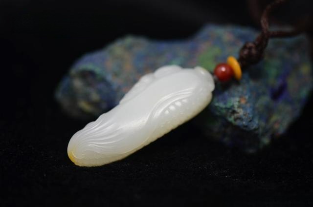 A Mutton-Fat White Hetian Nephrite Jade pendant with a rich, oily surface luster.