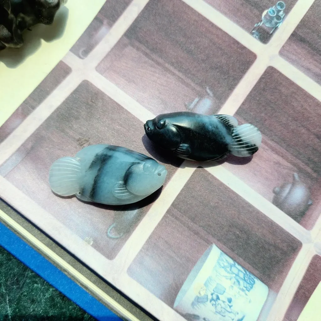 A black and white Nephrite Qinghua carving of two fish.