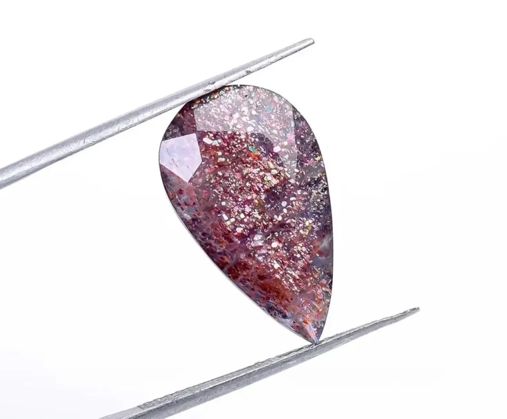 Pear-shaped Bloodshot Iolite gemstone showing fiery red hematite inclusions against a blue body.