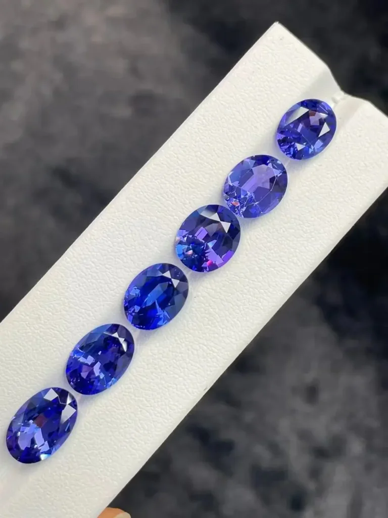 A group of precision-faceted Tanzanite gems in cushion, pear, and round brilliant cuts.