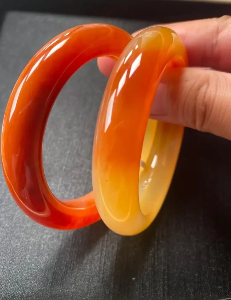 Pair of 56-57mm quartzite bangles in vibrant orange-red and honey-yellow tones.
