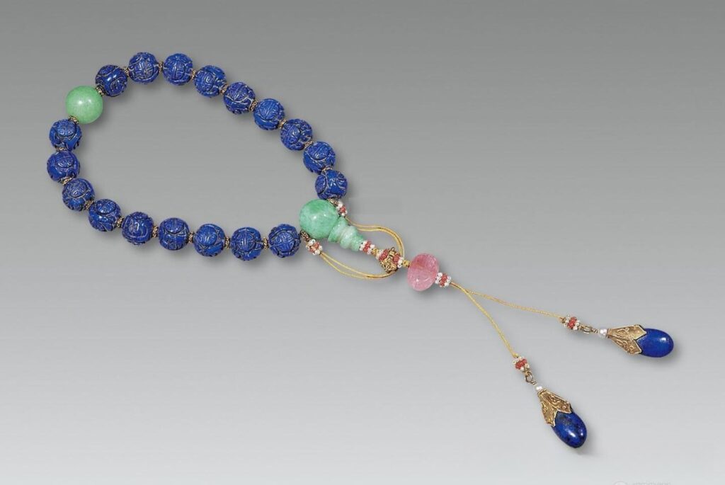 A Qing-style 18-bead  bracelet with tourmaline spacers and a silk tassel.