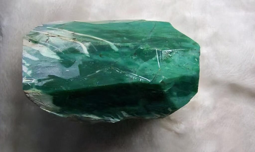 A raw Australian chrysoprase specimen with a vibrant apple-green color and waxy luster.