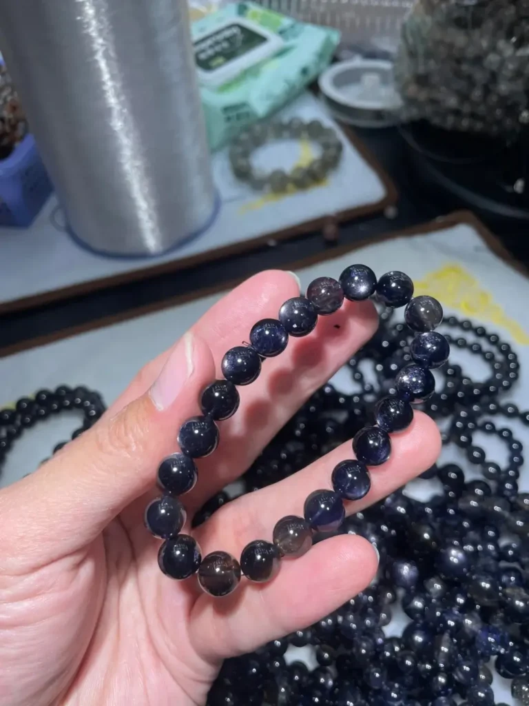 Close-up of Star Iolite beads displaying a four-rayed star effect on a yellowish-brown base.