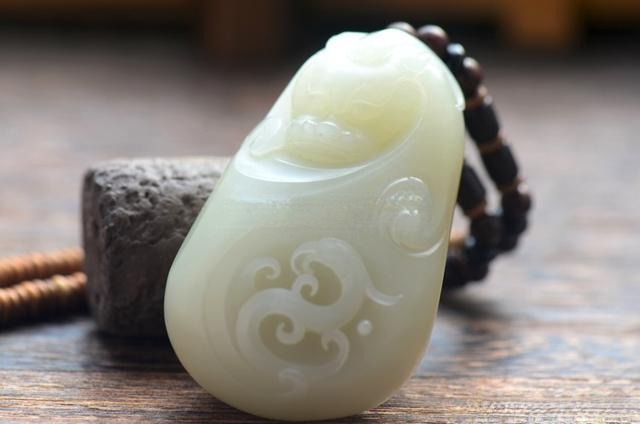 A "Dragon and Phoenix"  seed jade pendant with an eye-clean, structureless texture.