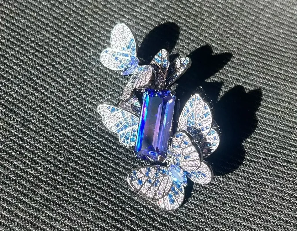 A tanzanite butterfly brooch sparkling in natural sunlight, featuring vivid violet-blue wing stones.