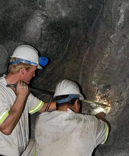 Tanzanian miners excavating gemstone veins inside a deep underground Merelani mine.