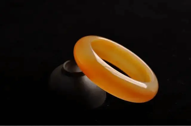Translucent yellow and red Huanglong Jade bangle with a smooth, jade-like luster.