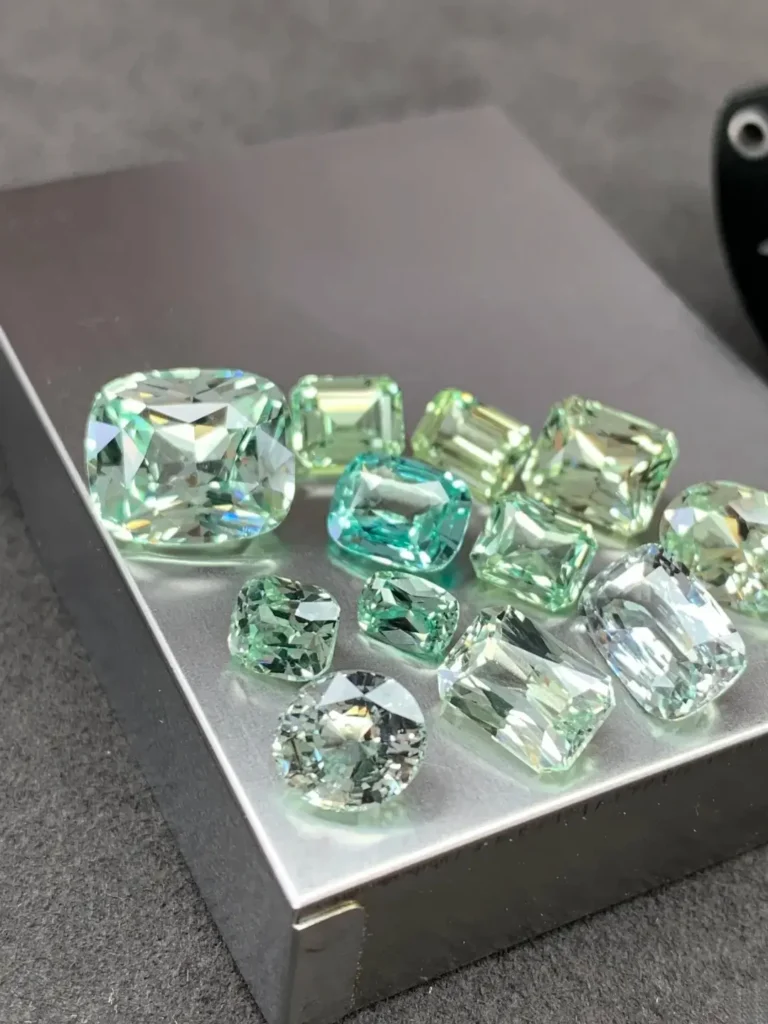 A selection of faceted vanadium chrysoberyls ranging from crisp mint green to near-colorless stones.