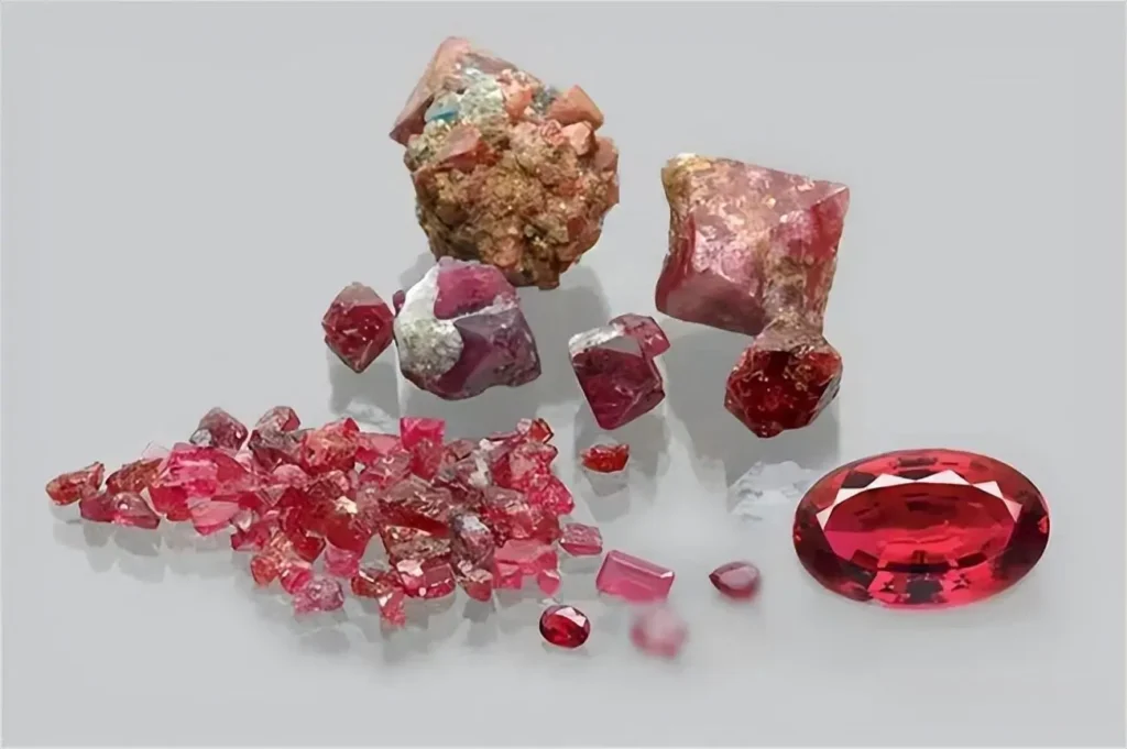 A collection of Mahenge spinel crystals, marble-hosted rough, and faceted neon pink gemstones.