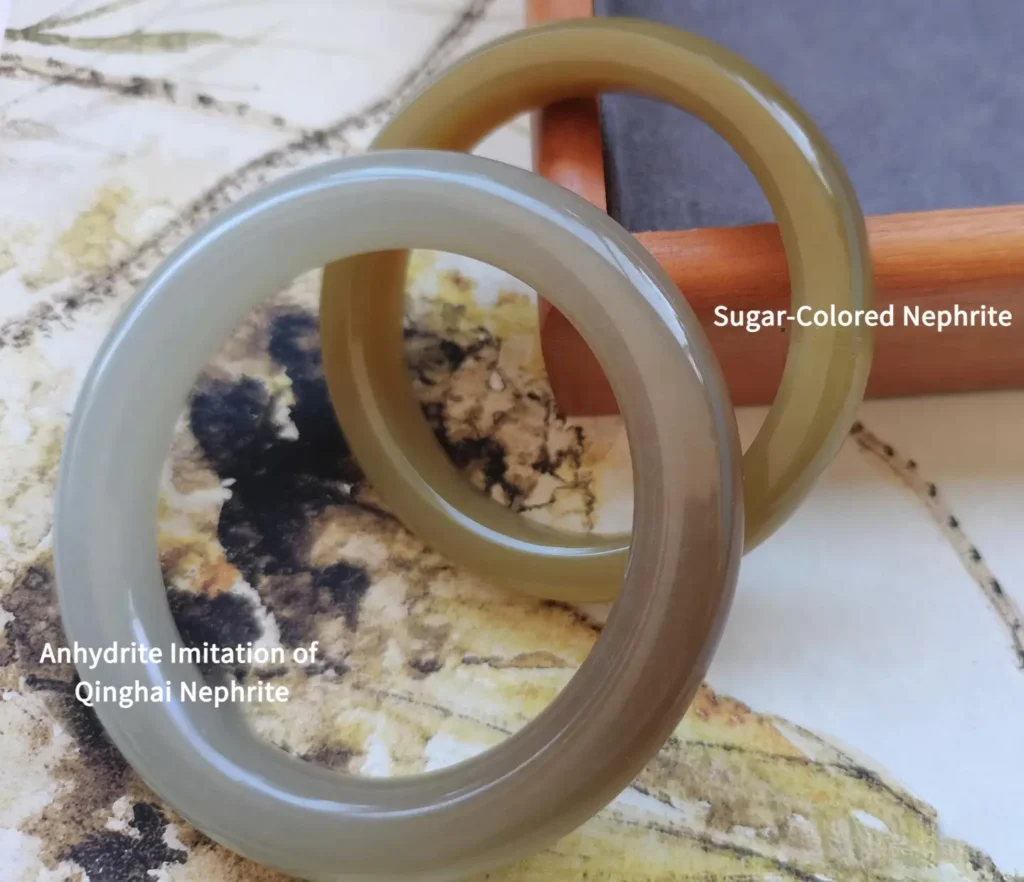 Comparison of an Anhydrite bangle and a natural Sugar-White Nephrite jade bangle side-by-side.