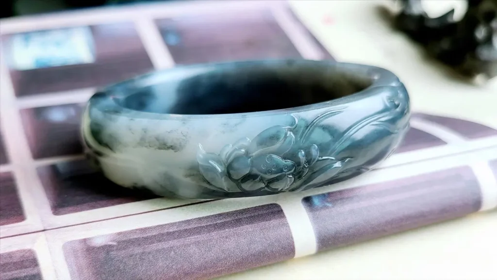 Authentic Qinghua Nephrite bangle with deep black pigmentation and a waxy luster.