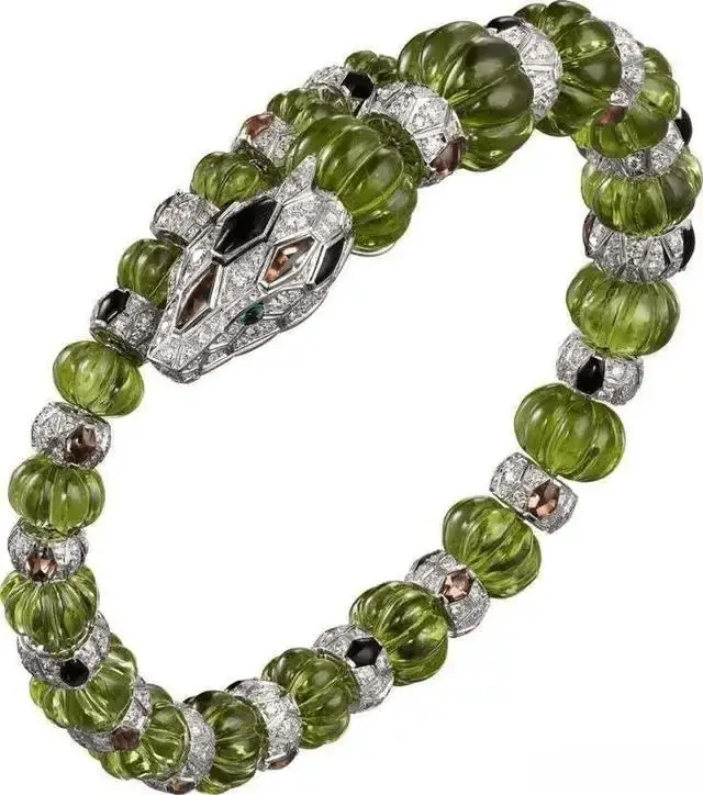 A high-end Cartier bracelet featuring vibrant green peridot stones set in 18K yellow gold.