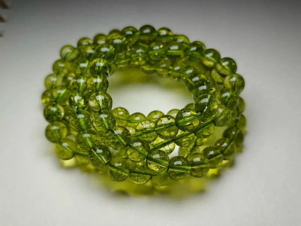 A beaded necklace made of large, dyed green glass beads as a common peridot imitation.