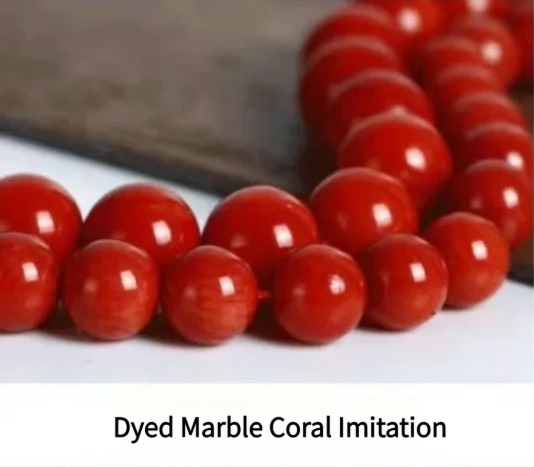 Dyed marble bead showing granular, crystalline texture characteristic of stone-based coral imitations.