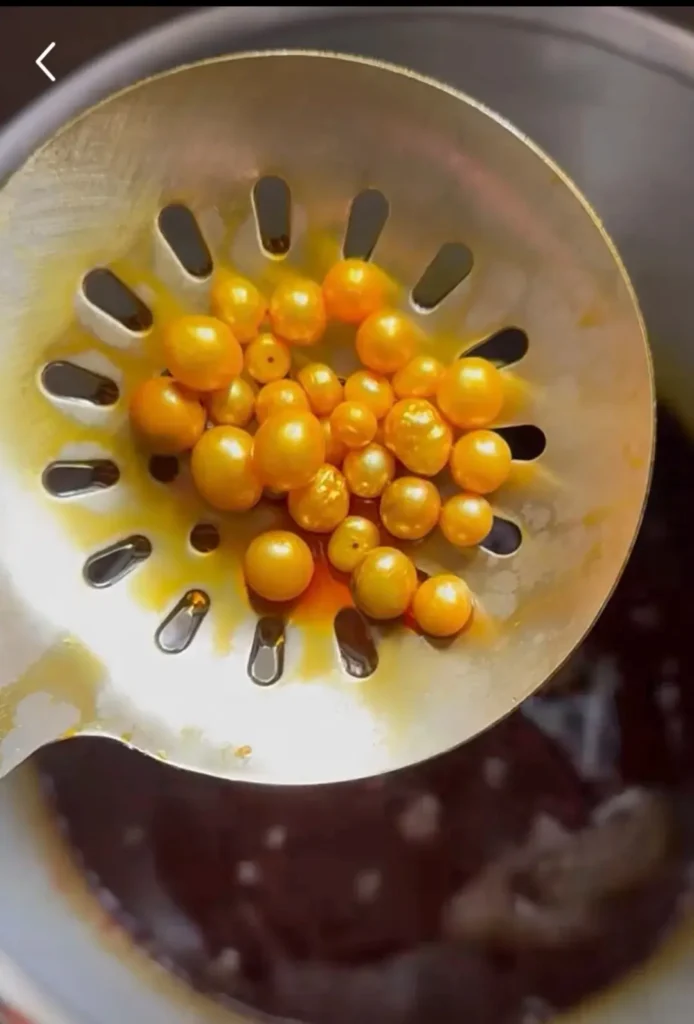 Close-up of pearls undergoing chemical dyeing, a common Pearl Color Treatment in liquid baths.