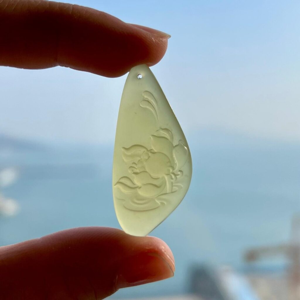 Translucent Icy-Yellow Huangkou Nephrite jade pendant carved with a lotus flower motif.