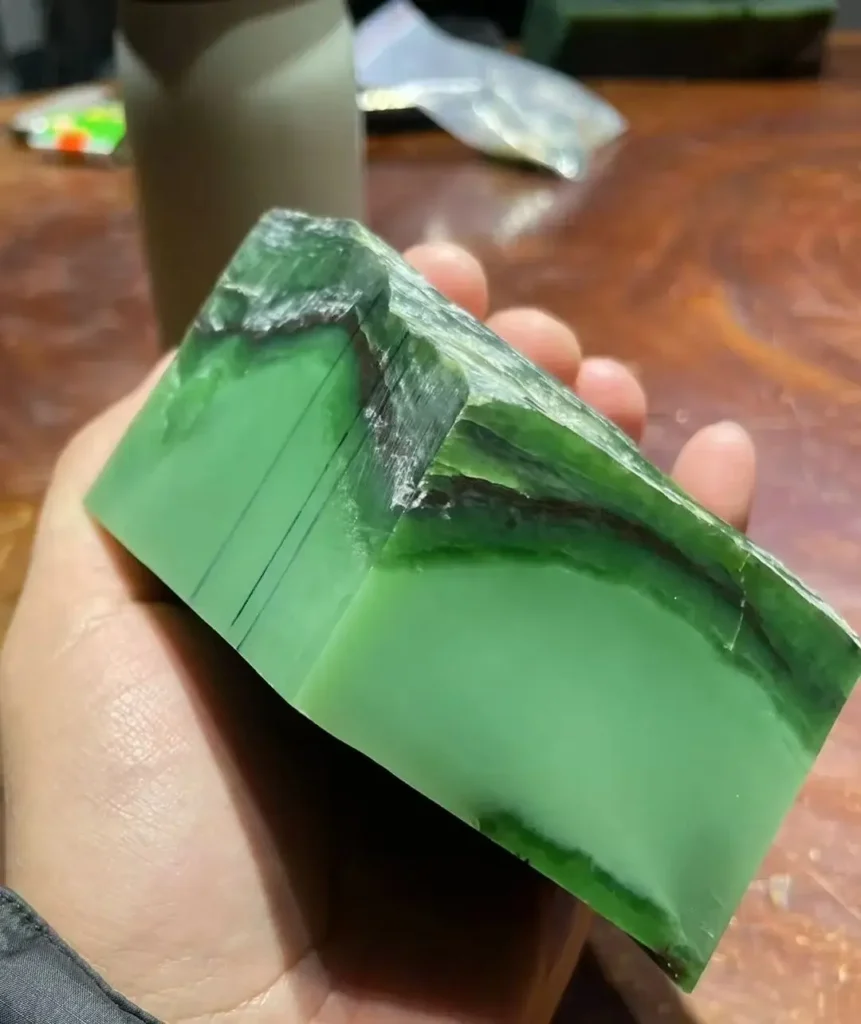 High-density interlayer green nephrite raw slice showing a structureless, fine grain.
