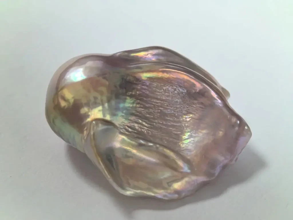 A baroque pearl displaying strong orient with drifting, rainbow-like iridescent shimmer.