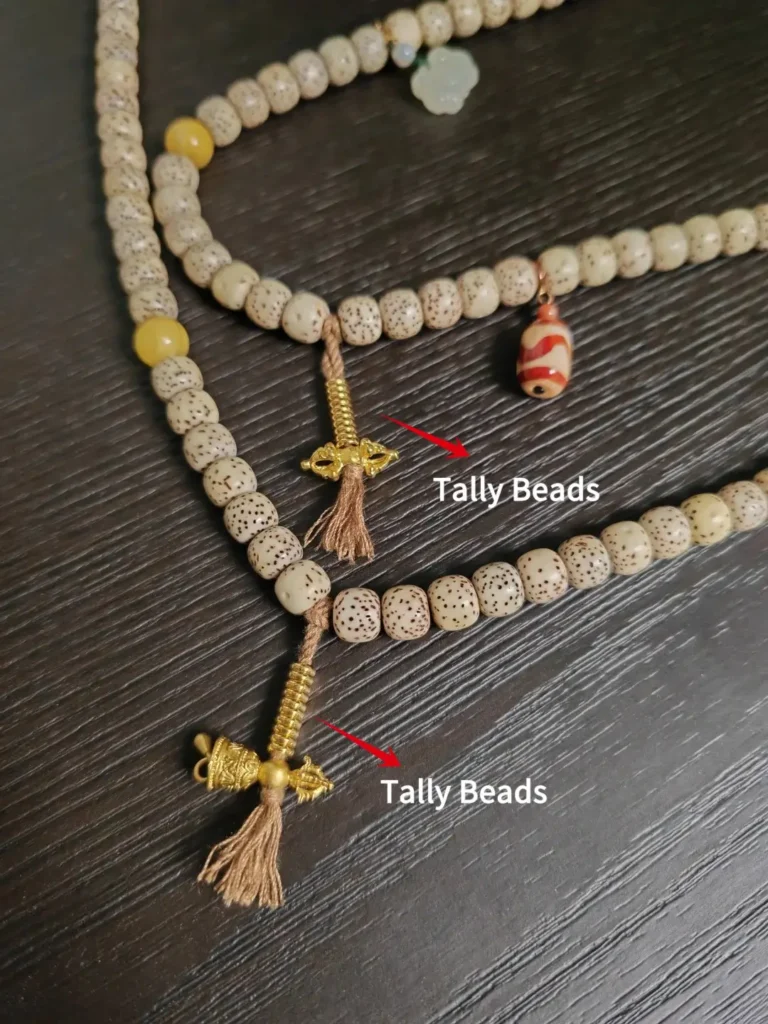 A diagram of Mala beads anatomy with arrows pointing to the symmetrical counting strands.