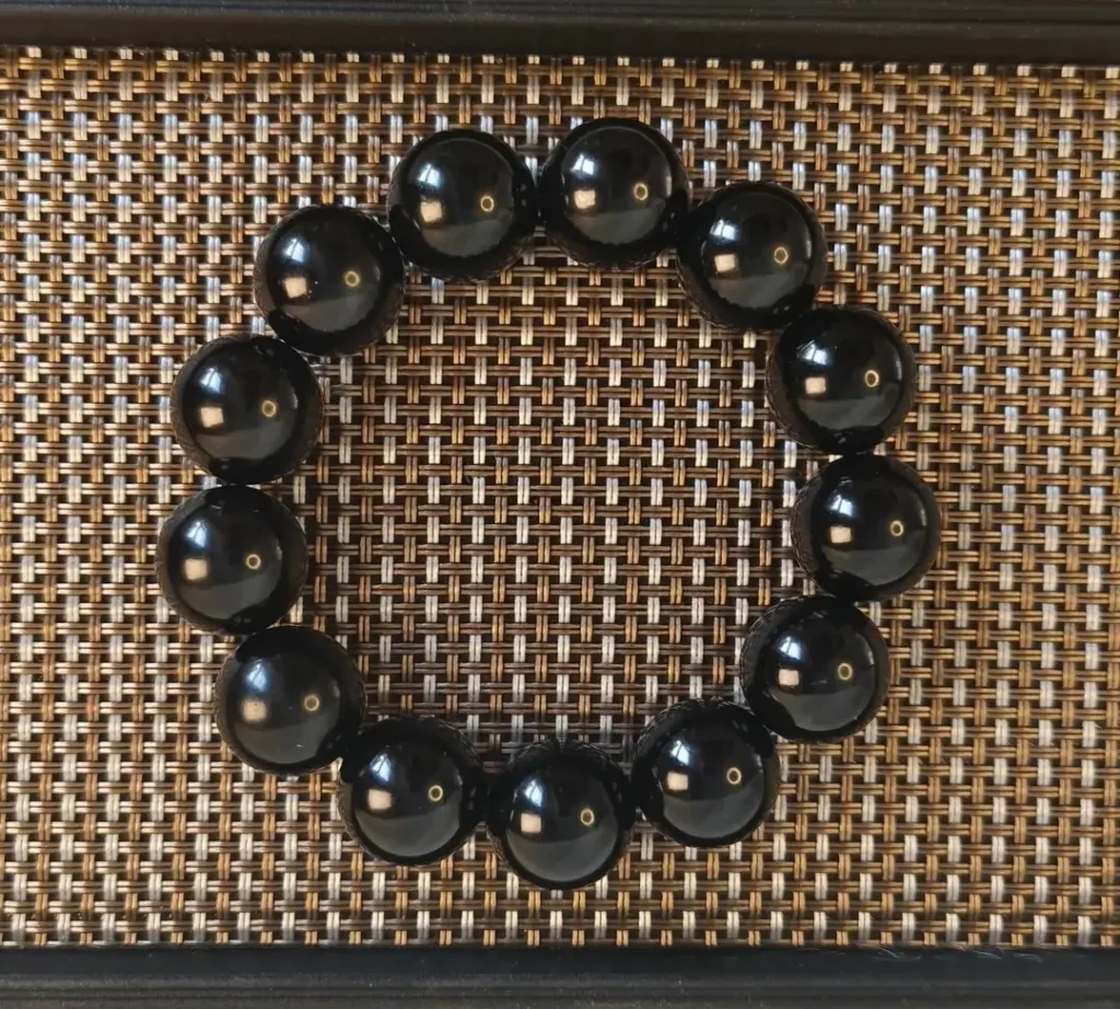 A polished Mo Yu (Black Nephrite) bead bracelet showing a rich, oily luster and fine texture.
