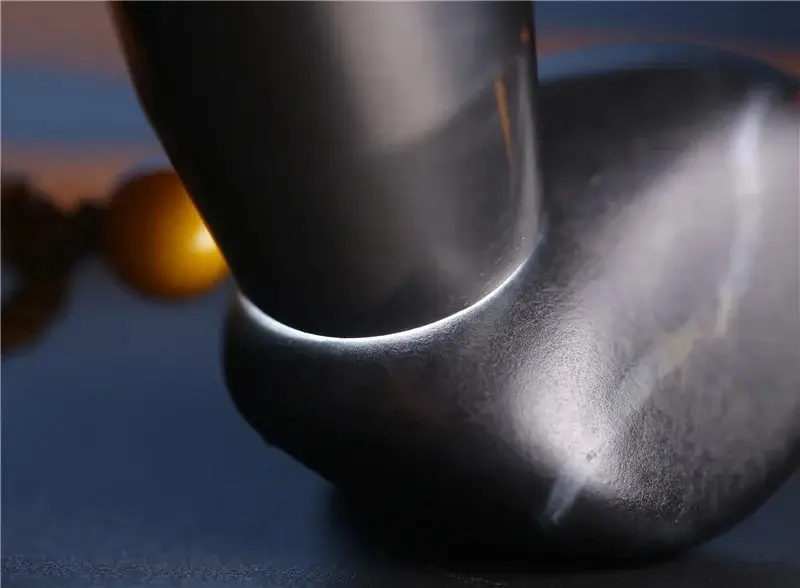 A Black Hetian Jade (Mo Yu) seed stone showing white light transmission during a backlighting test.