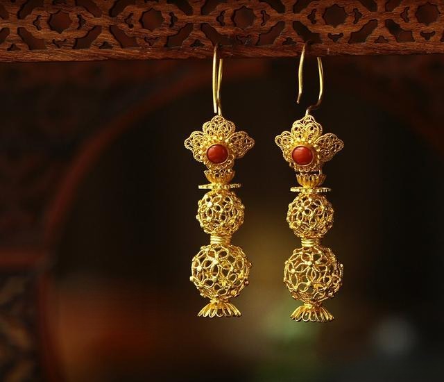 Modern gold-plated copper earrings featuring traditional Chinese filigree patterns and floral motifs.