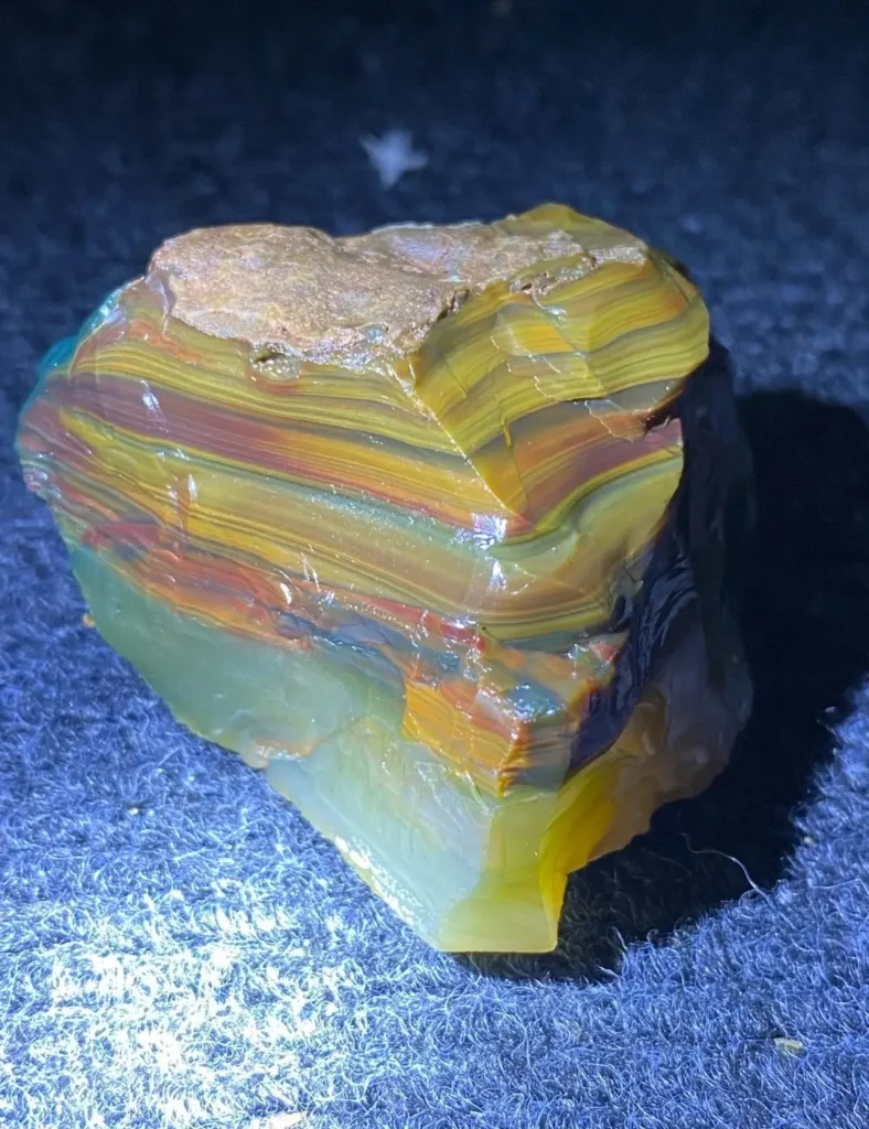 Polished Alashan showing natural layers of saturated green, pink, and yellow mineral zones.