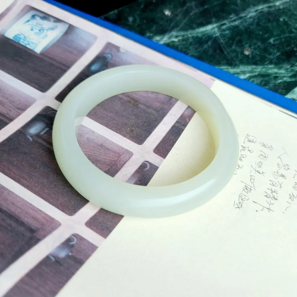 Top-grade Mutton-Fat Nephrite Seed Jade bangle with a dense, oily, and opaque white body.
