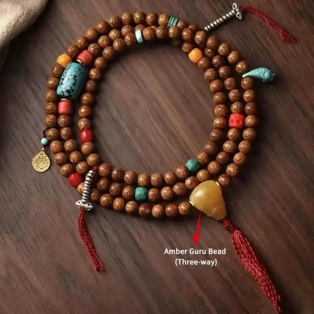 Close-up of a 108 Mala highlighting a natural beeswax amber Guru bead with an arrow.