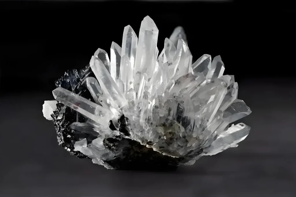 A natural cluster of Clear Quartz showing characteristic hexagonal prismatic crystals and pointed terminations.