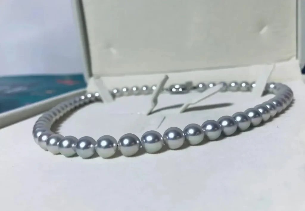 A high-quality Akoya pearl necklace featuring natural silver-grey Madama hues and metallic luster.