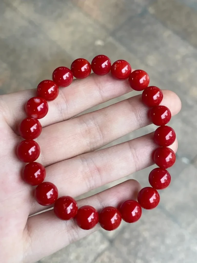A string of premium oxblood Aka coral beads displaying deep red color and glassy luster.