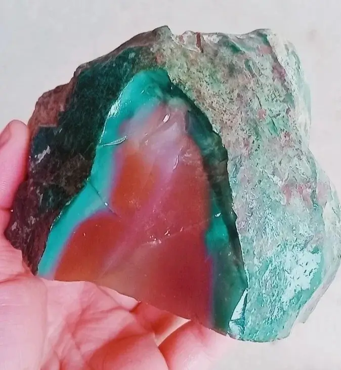 Cross-section of Purple-Green Agate showing a green outer layer encircling a vivid red mineral core.