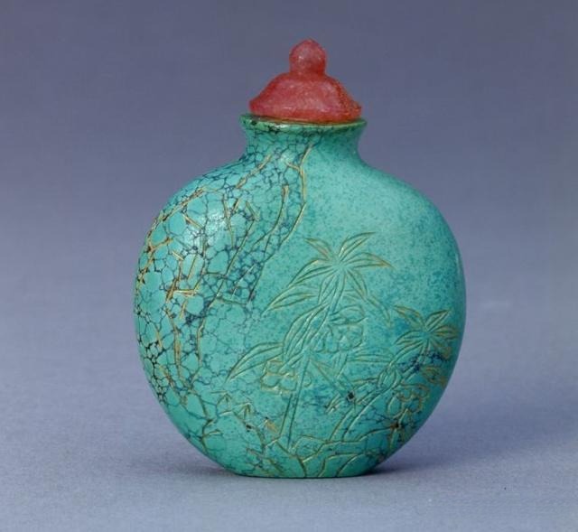 Qing Dynasty turquoise snuff bottle from the Palace Museum with floral and rock carvings.