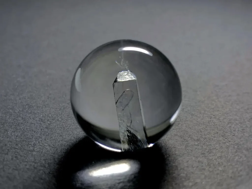 A 22.77mm clear quartz sphere featuring a perfectly formed, distinct crystal inclusion inside.
