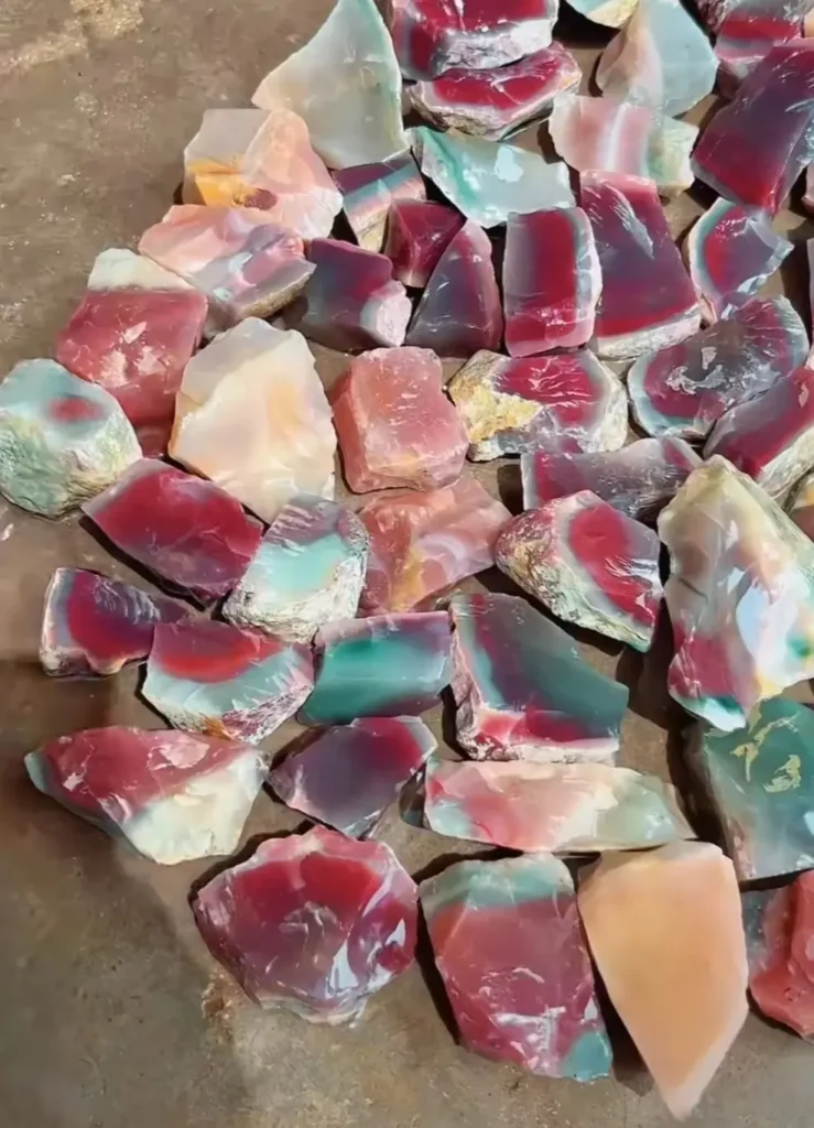 Raw Purple-Green Agate nodules from Luonan County arranged on the ground for sorting.