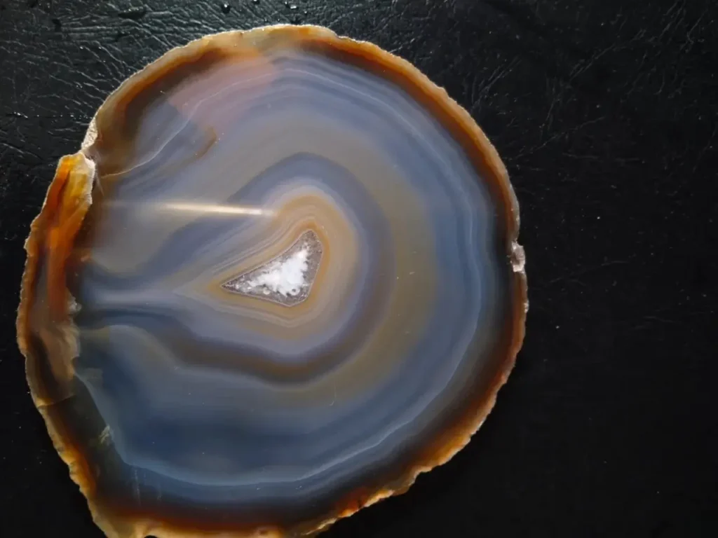 Raw banded agate featuring distinct, parallel layers of reddish-brown and white mineral bands.