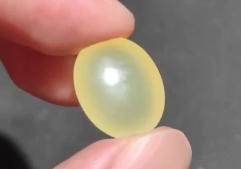 Small Icy-Yellow Xiuyan Jade cabochon with high transparency and an even, pale yellow hue.