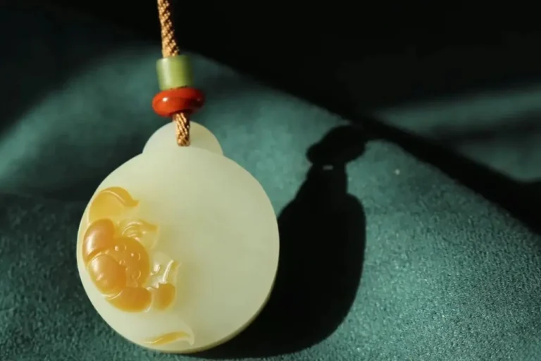 Round Sugar-White Nephrite Jade pendant with a delicately carved lotus flower.