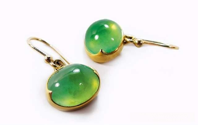 A pair of 18K gold earrings set with vibrant yellow-green Jin Cui Yu cabochons.