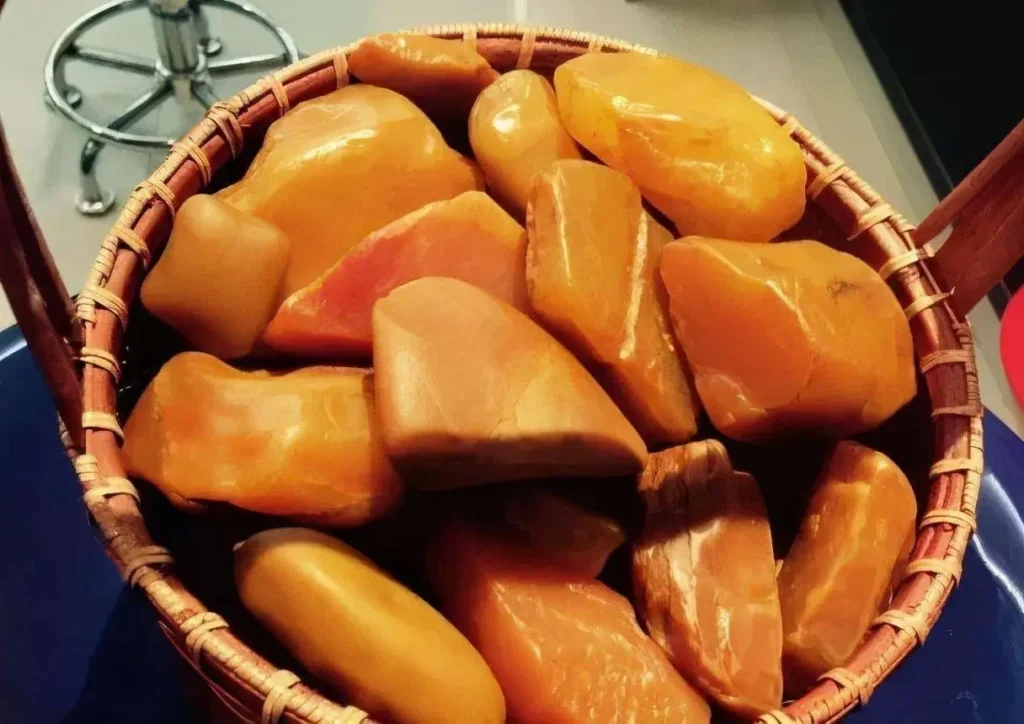 A basket of raw Jiangxi Yellow Wax Stones with vibrant golden hues and waxy textures.