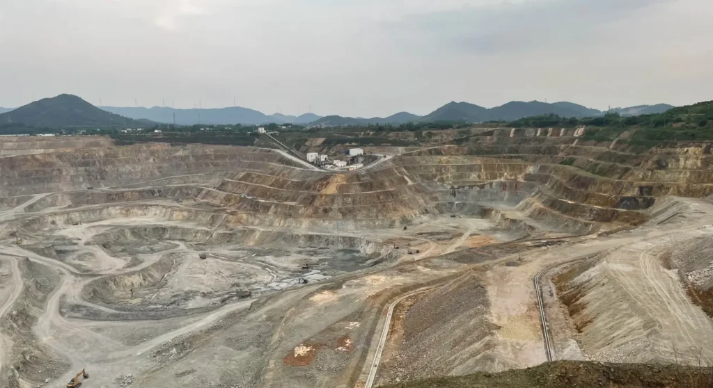 A massive abandoned open-pit mine in Gansu showing deep geological layers and industrial excavation.