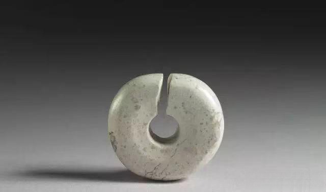 An 8,000-year-old C-shaped Xiuyan jade ear ornament known as a Jue, from the Neolithic era.