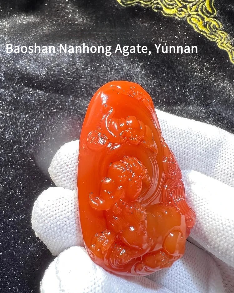 Natural Baoshan Nanhong agate pendant with intricate traditional Chinese carving and waxy luster.