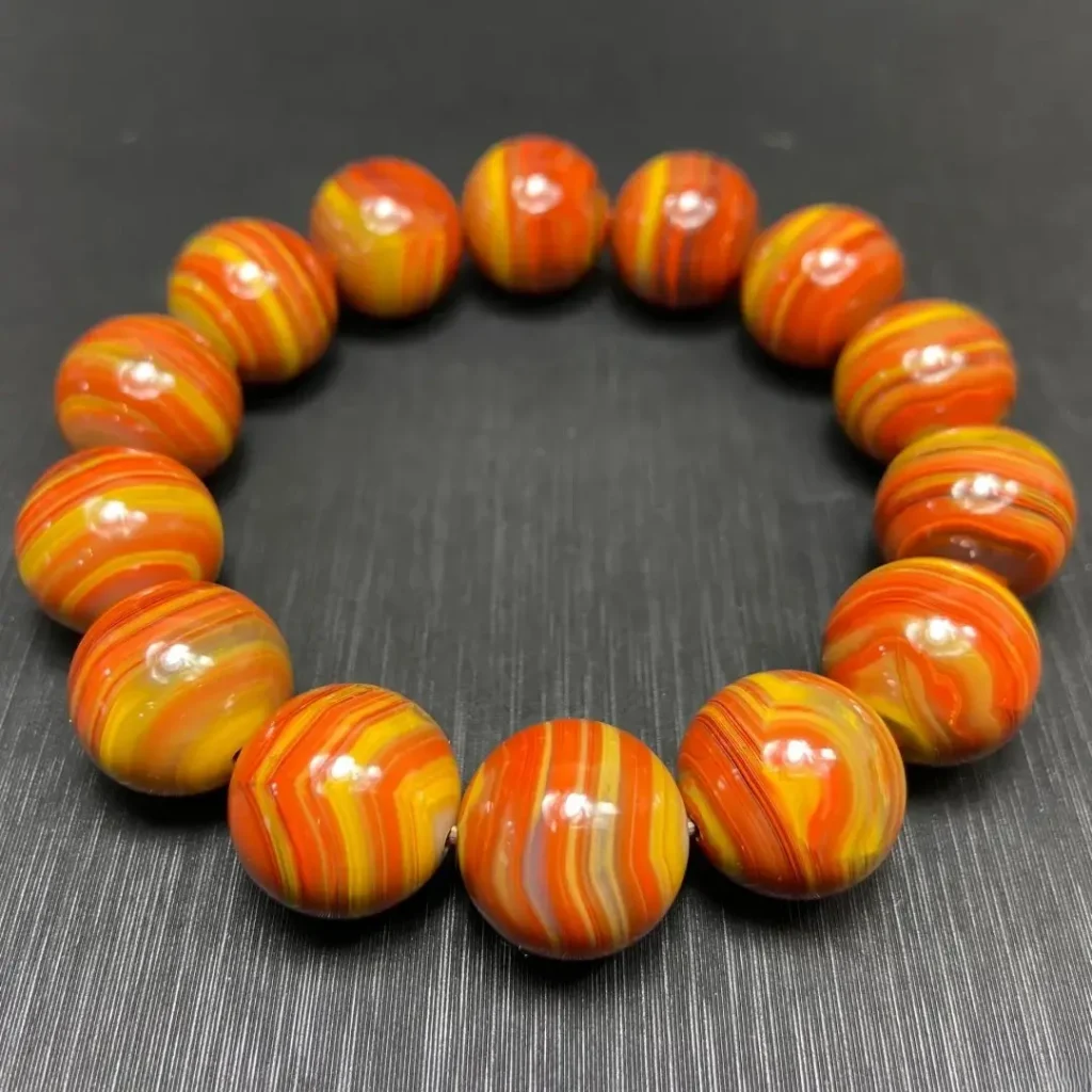 Beipiao Zhan-Guo Red agate bead bracelet from Liaoning with vibrant red and yellow banding.