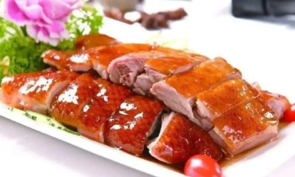 Platter of Cantonese roast goose with glass-like crispy skin and an amber honey-glazed luster.