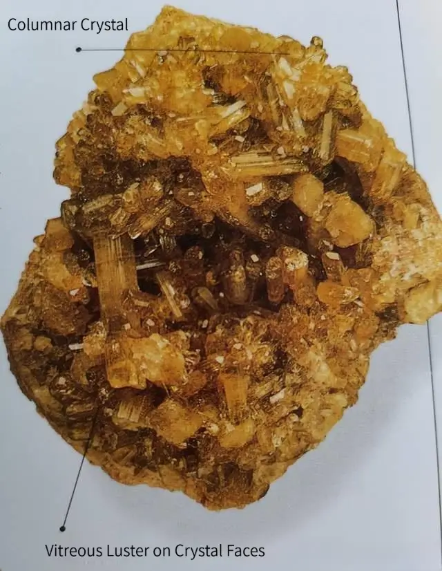 A raw columnar Vesuvianite crystal with sharp faces and a brilliant vitreous luster.