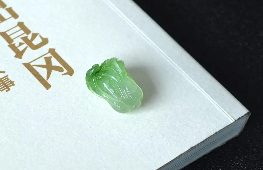 Cui Qing Nephrite carving of a Chinese cabbage with natural green leaves and a white base.