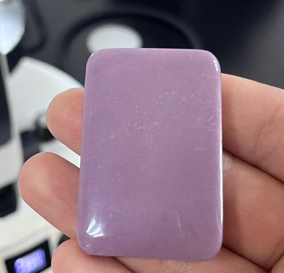 A purple Hetian jade plaque identified as dyed and treated by professional lab testing.